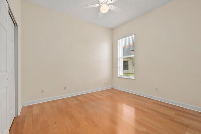 unfurnished bedroom with baseboards, light wood-style flooring, and a closet