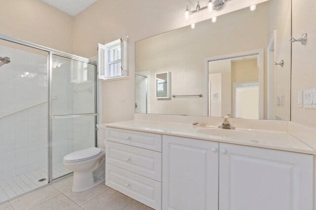 bathroom featuring vanity, tile patterned floors, a stall shower, and toilet