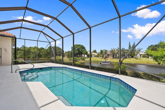 outdoor pool featuring a water view, a patio area, and a lanai