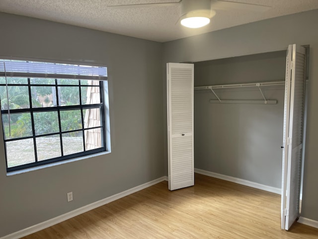 4237 Oak Terrace Dr, Greenacres, FL 33463 - unfurnished bedroom featuring ceiling fan, a textured ceiling, baseboards, a closet, and light wood finished floors