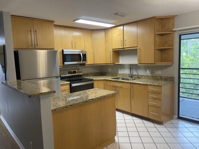 4237 Oak Terrace Dr, Greenacres, FL 33463 - kitchen with open shelves, appliances with stainless steel finishes, a sink, dark stone counters, and visible vents