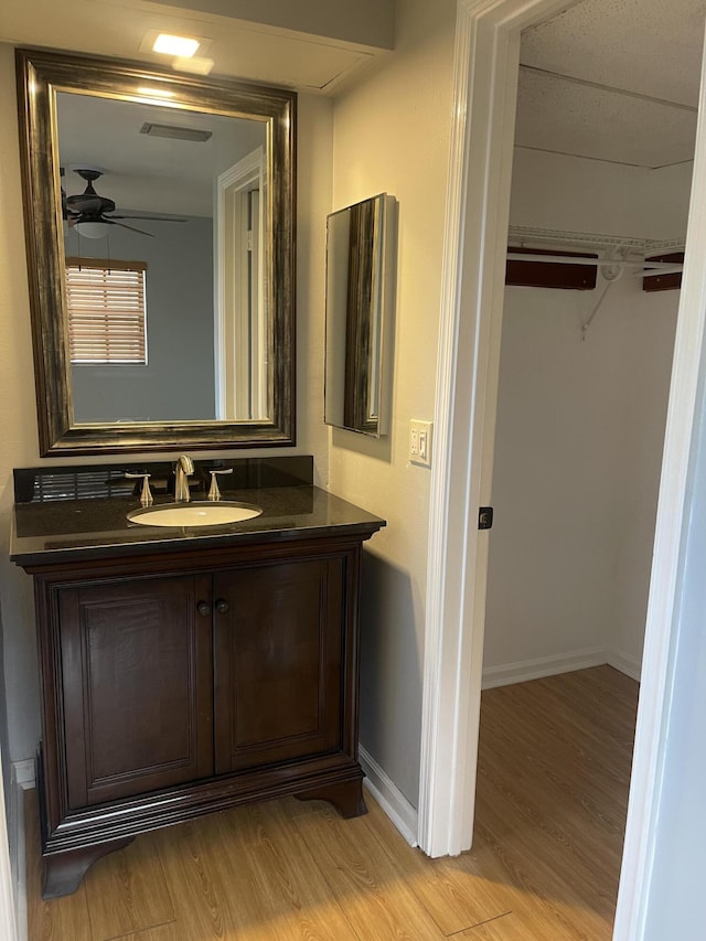 4237 Oak Terrace Dr, Greenacres, FL 33463 - bathroom with baseboards, a ceiling fan, wood finished floors, and vanity