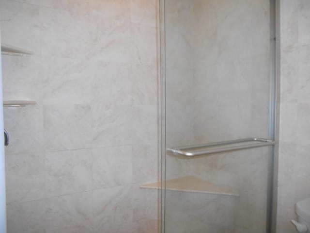 room details featuring toilet and a shower stall