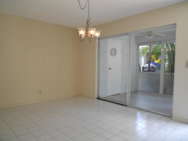spare room featuring light tile patterned flooring and a notable chandelier