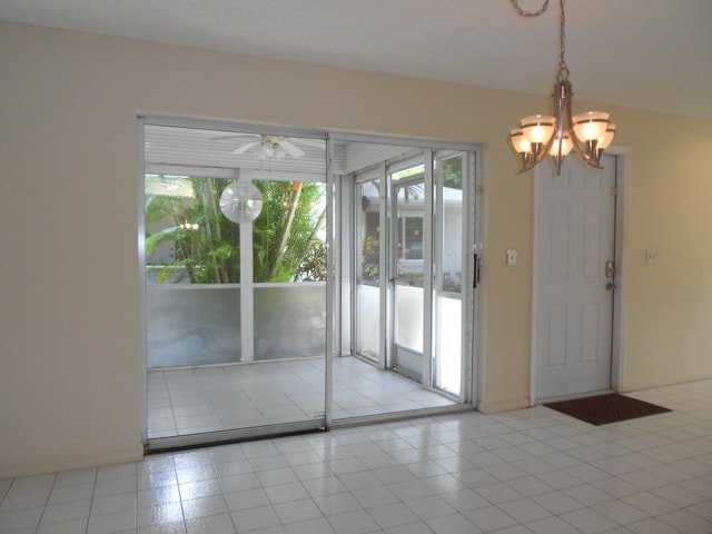 interior space featuring baseboards, ceiling fan with notable chandelier, and light tile patterned floors
