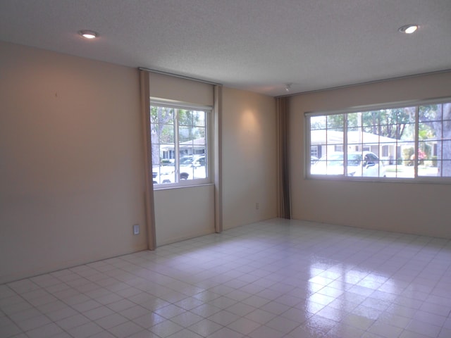 unfurnished room featuring recessed lighting and a textured ceiling