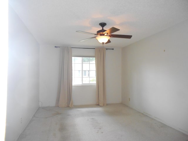 spare room featuring ceiling fan and light colored carpet