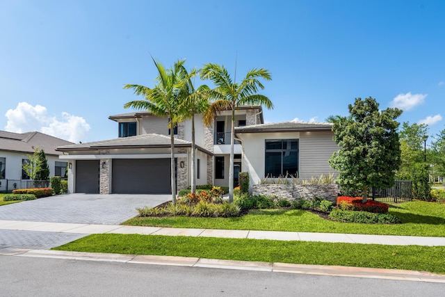 10715 Estuary Dr, Parkland, FL 33076 - view of front facade with a front yard, decorative driveway, fence, an attached garage, and stone siding