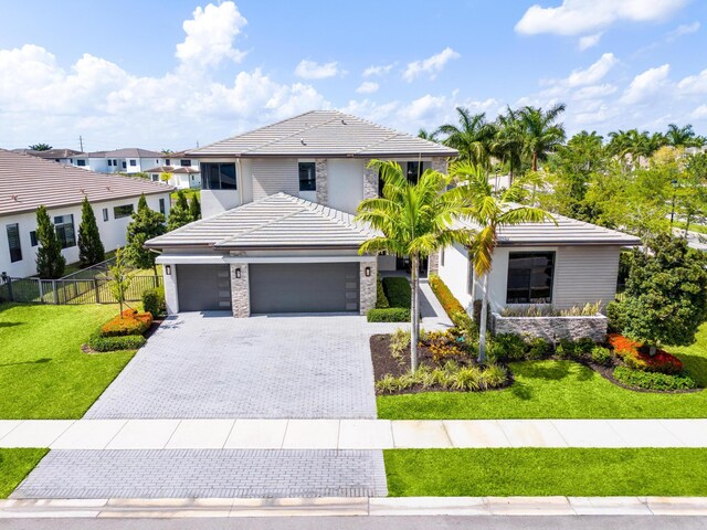 10715 Estuary Dr, Parkland, FL 33076 - traditional-style home with fence, an attached garage, a front lawn, stone siding, and decorative driveway