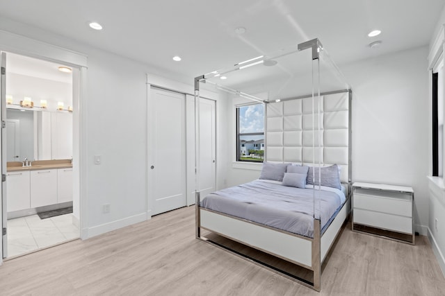 10715 Estuary Dr, Parkland, FL 33076 - bedroom with a sink, baseboards, light wood-type flooring, and connected bathroom
