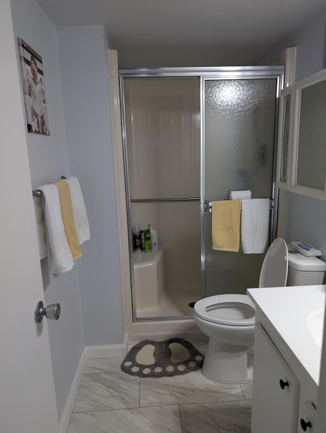 full bath with vanity, a stall shower, toilet, and marble finish floor