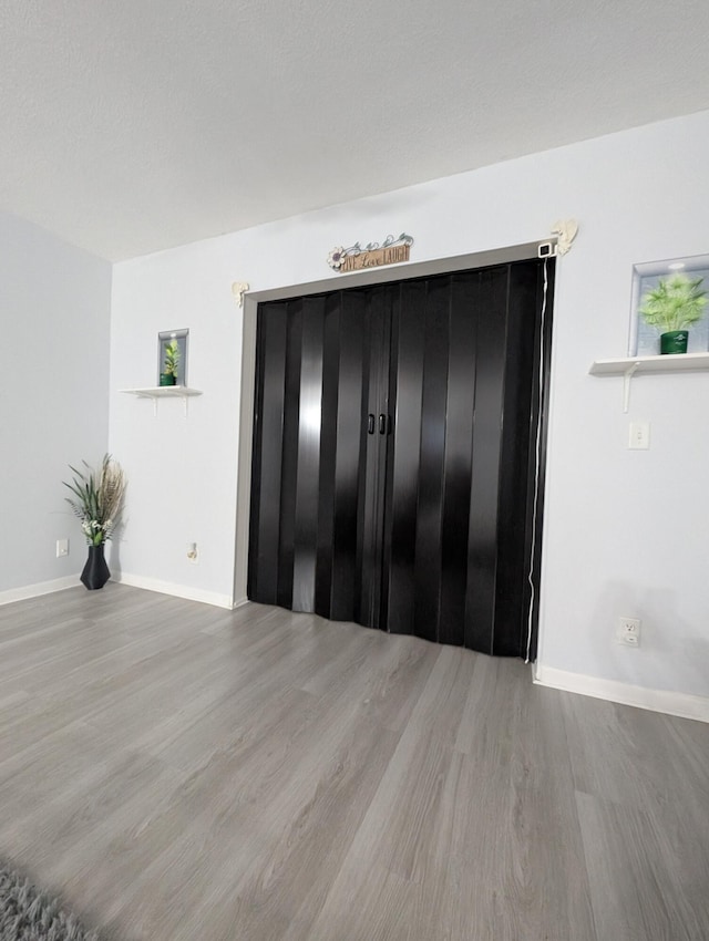 interior space with baseboards and wood finished floors