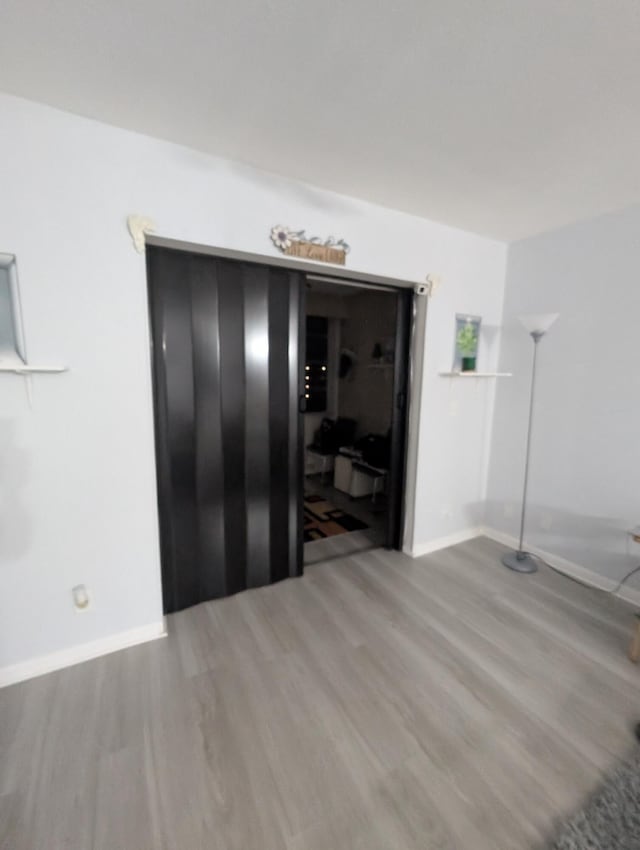 unfurnished room featuring baseboards and wood finished floors