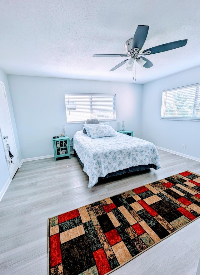 bedroom with baseboards, light wood-style flooring, and ceiling fan