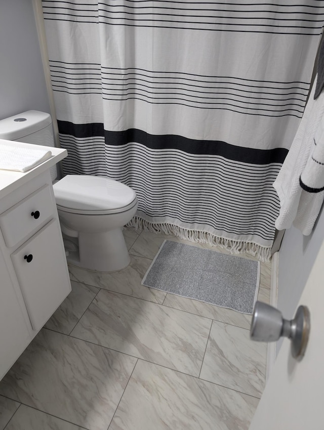 full bathroom featuring vanity, toilet, curtained shower, and marble finish floor