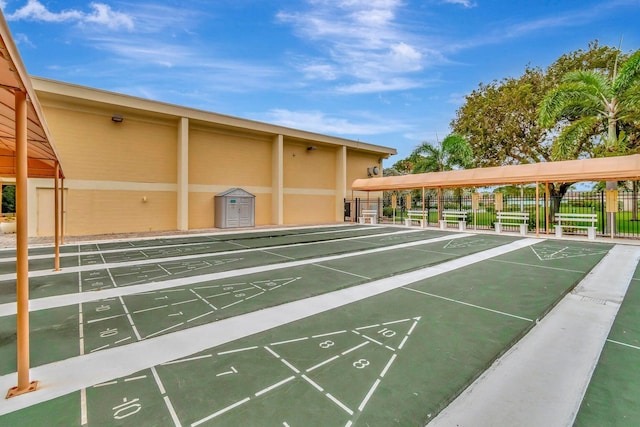 view of property's community featuring fence and shuffleboard