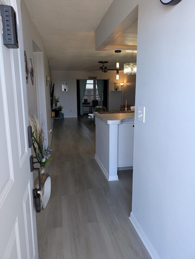 hall with dark wood-style flooring and baseboards