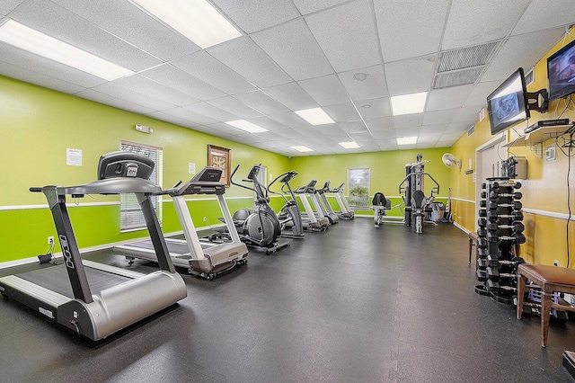 workout area featuring baseboards, visible vents, and a paneled ceiling