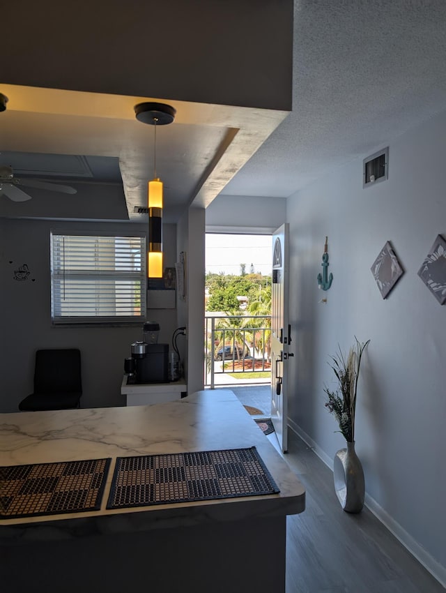 home office with visible vents, baseboards, ceiling fan, and wood finished floors
