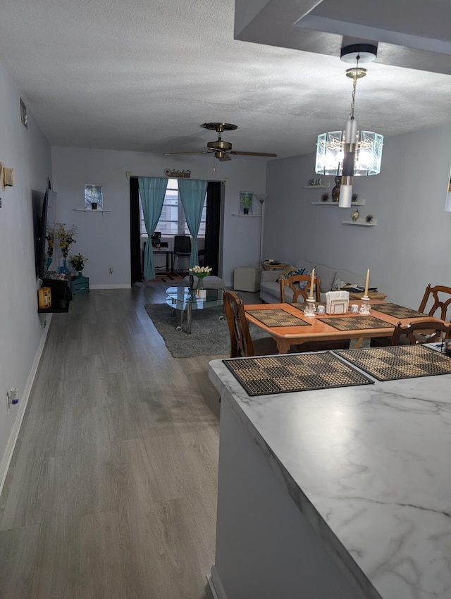 dining space with baseboards, ceiling fan, wood finished floors, and a wealth of natural light