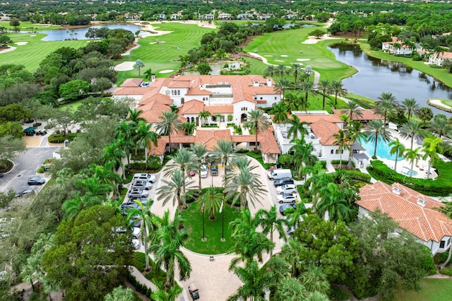 birds eye view of property with a water view and view of golf course