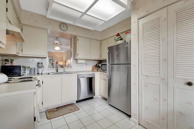 6585 Kensington Ln Unit 307, Delray Beach, FL 33446 - kitchen featuring stainless steel appliances, light countertops, under cabinet range hood, light tile patterned flooring, and a sink
