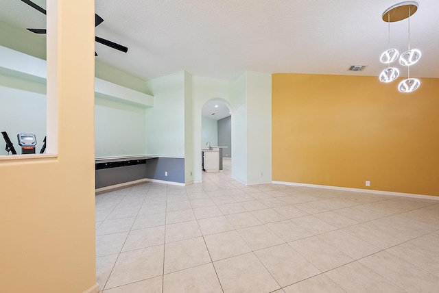 500 N Cypress Dr, Tequesta, FL 33469 - tiled spare room featuring a ceiling fan, arched walkways, and baseboards