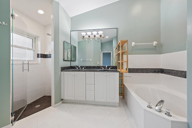 500 N Cypress Dr, Tequesta, FL 33469 - full bath featuring a stall shower, a garden tub, double vanity, tile patterned floors, and a chandelier