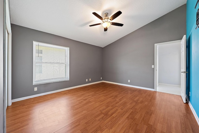 500 N Cypress Dr, Tequesta, FL 33469 - empty room featuring vaulted ceiling, ceiling fan, wood finished floors, baseboards, and a textured ceiling