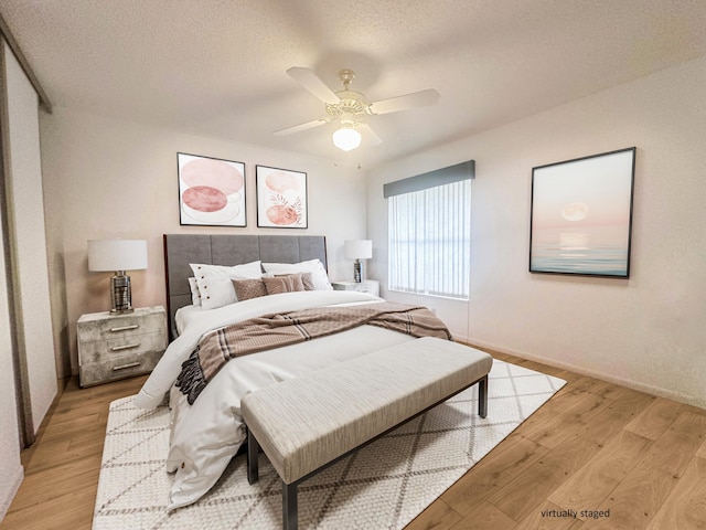 3206 Carambola Cir S, Coconut Creek, FL 33066 - bedroom with baseboards, a textured ceiling, light wood-style flooring, and a ceiling fan