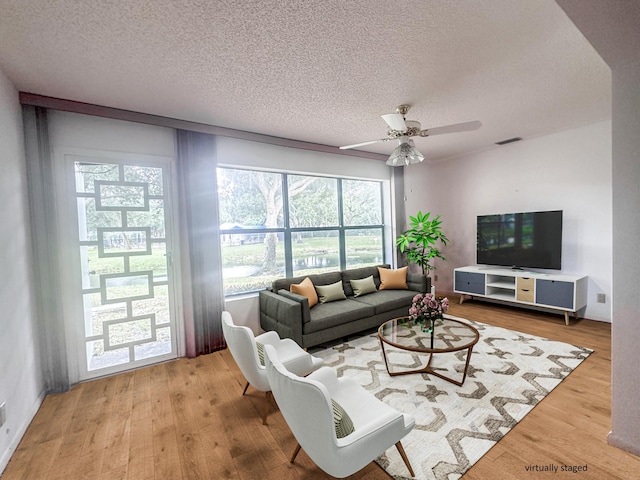 3206 Carambola Cir S, Coconut Creek, FL 33066 - living area with light wood-style floors, visible vents, ceiling fan, and a textured ceiling