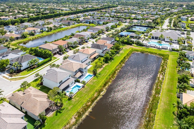 aerial perspective of suburban area featuring a large body of water and a pool area