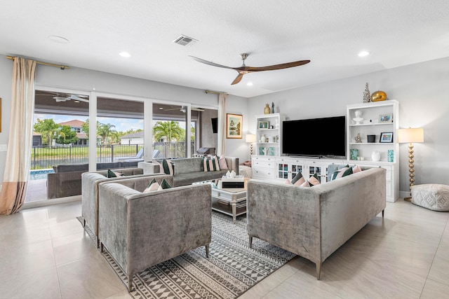 living room with a ceiling fan, recessed lighting, and a textured ceiling