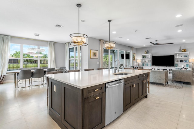 kitchen featuring dishwasher, a sink, dark brown cabinetry, light countertops, and plenty of natural light