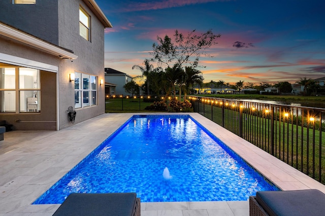 pool at dusk with a patio area