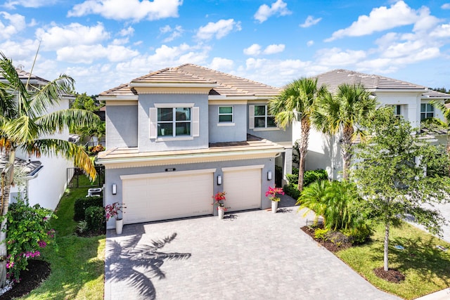 view of front of home with an attached garage, stucco siding, driveway, and a tile roof