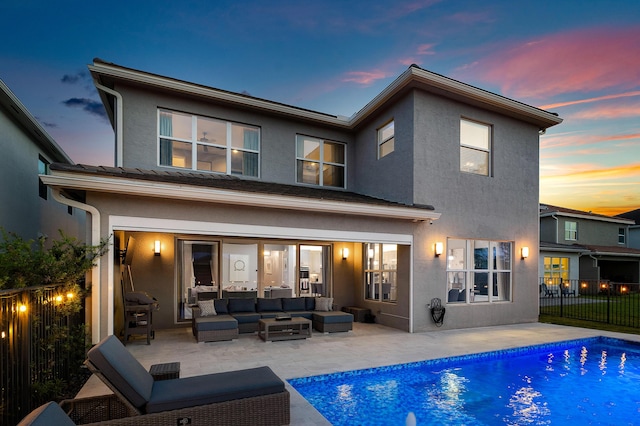 rear view of property featuring outdoor lounge area, stucco siding, and a patio area