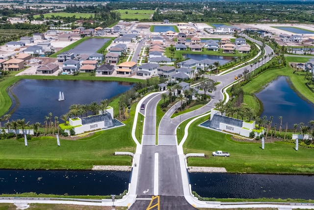 aerial view of property and surrounding area featuring a nearby body of water and nearby suburban area