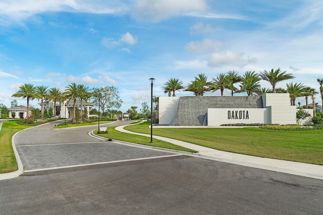 view of asphalt street featuring street lights, curbs, and sidewalks