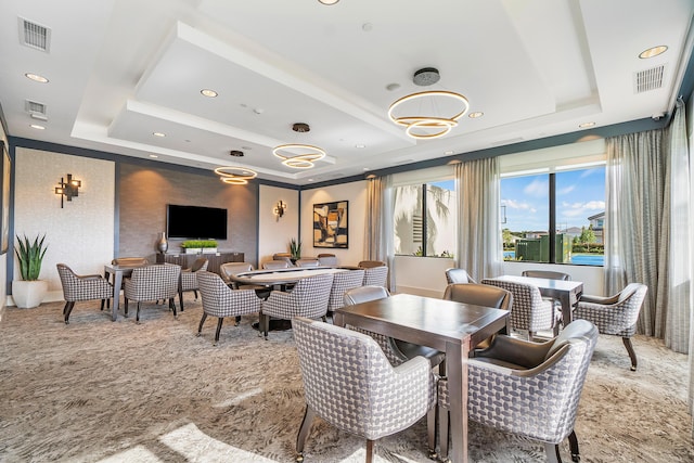 dining space featuring a raised ceiling, recessed lighting, and carpet