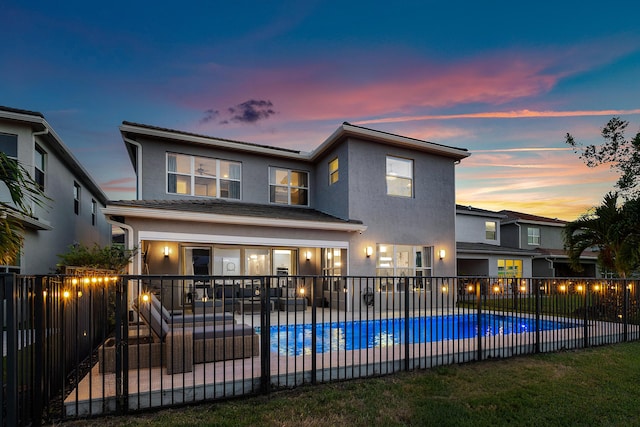 back of house at dusk with a patio area, a fenced backyard, and stucco siding