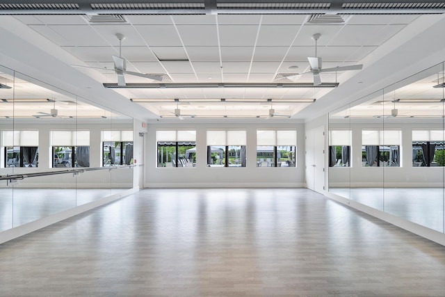 exercise room featuring wood finished floors, healthy amount of natural light, and a ceiling fan