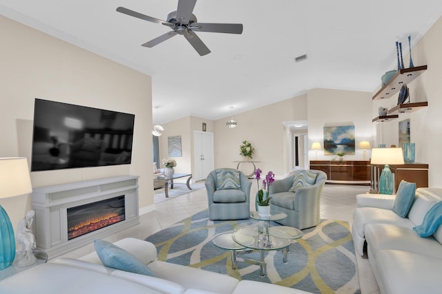 living area with lofted ceiling, tile patterned flooring, ceiling fan, and a glass covered fireplace