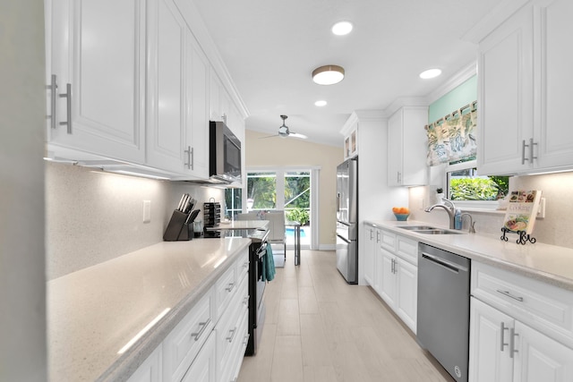 kitchen featuring appliances with stainless steel finishes, a sink, light countertops, a ceiling fan, and recessed lighting