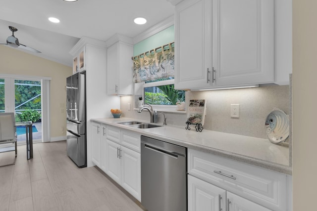 kitchen featuring stainless steel appliances, a sink, plenty of natural light, tasteful backsplash, and recessed lighting