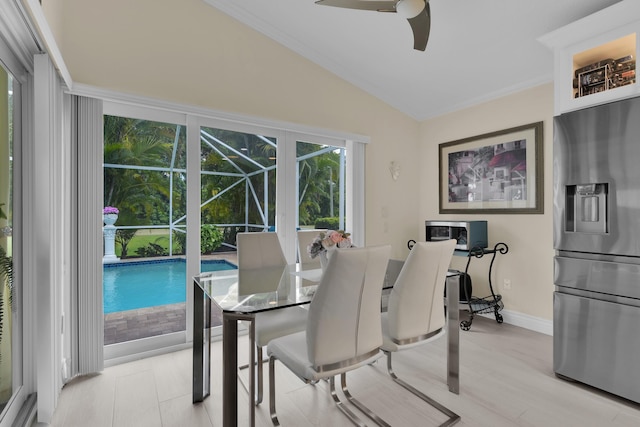 dining room with a sunroom, a ceiling fan, vaulted ceiling, and baseboards