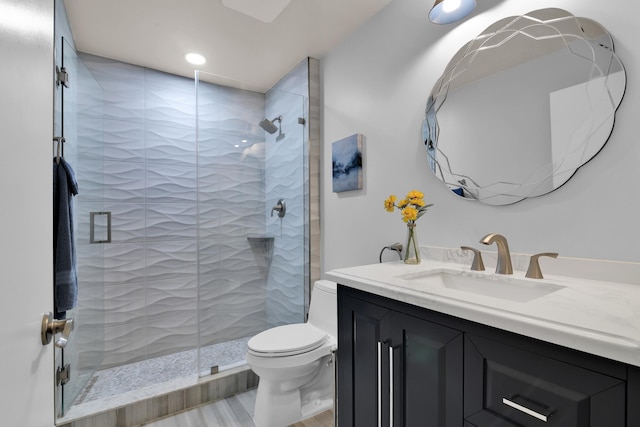 full bathroom featuring toilet, a shower stall, vanity, and recessed lighting