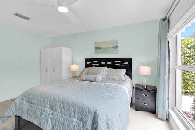 bedroom with multiple windows, a ceiling fan, and light tile patterned floors