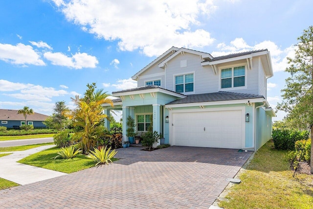 traditional home with a garage and decorative driveway