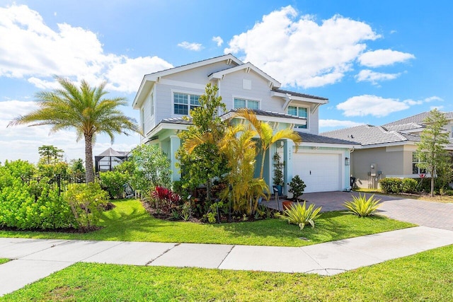 view of front facade with stucco siding, decorative driveway, a front yard, and a garage
